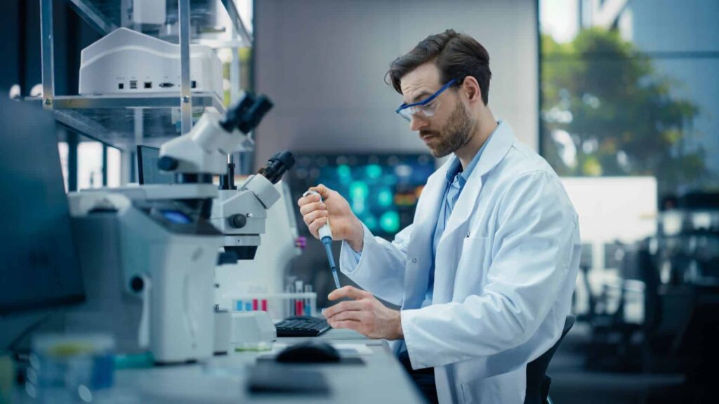 Scientist using pipette in modern laboratory